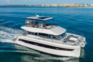 Luxury yacht sailing in clear blue waters near Miami, showcasing spacious deck and modern design, ideal for premium yacht rentals and charters.