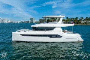 Luxurious white yacht cruising in Miami waters with city skyline and palm trees in the background, perfect for rental and charter experiences.