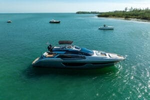 A sleek luxury yacht cruising in the clear blue waters of Miami, surrounded by other smaller boats, showcasing the premium rental experience available for unmatched yacht charters in Miami.