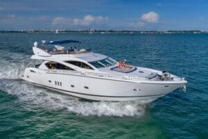 Luxury yacht cruising in Miami waters, offering unmatched charter experiences, featuring a sleek white design with people relaxing on deck.