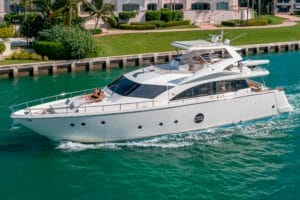 Luxurious white yacht cruising in the clear turquoise waters of Miami, featuring spacious decks and sunbathing areas, exemplifying premium Miami yacht rentals and charters for unforgettable experiences.