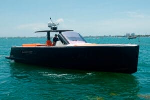 Luxurious black yacht with orange accents cruising on Miami's blue waters, ideal for island-hopping and day cruises with Wonder Yachting.